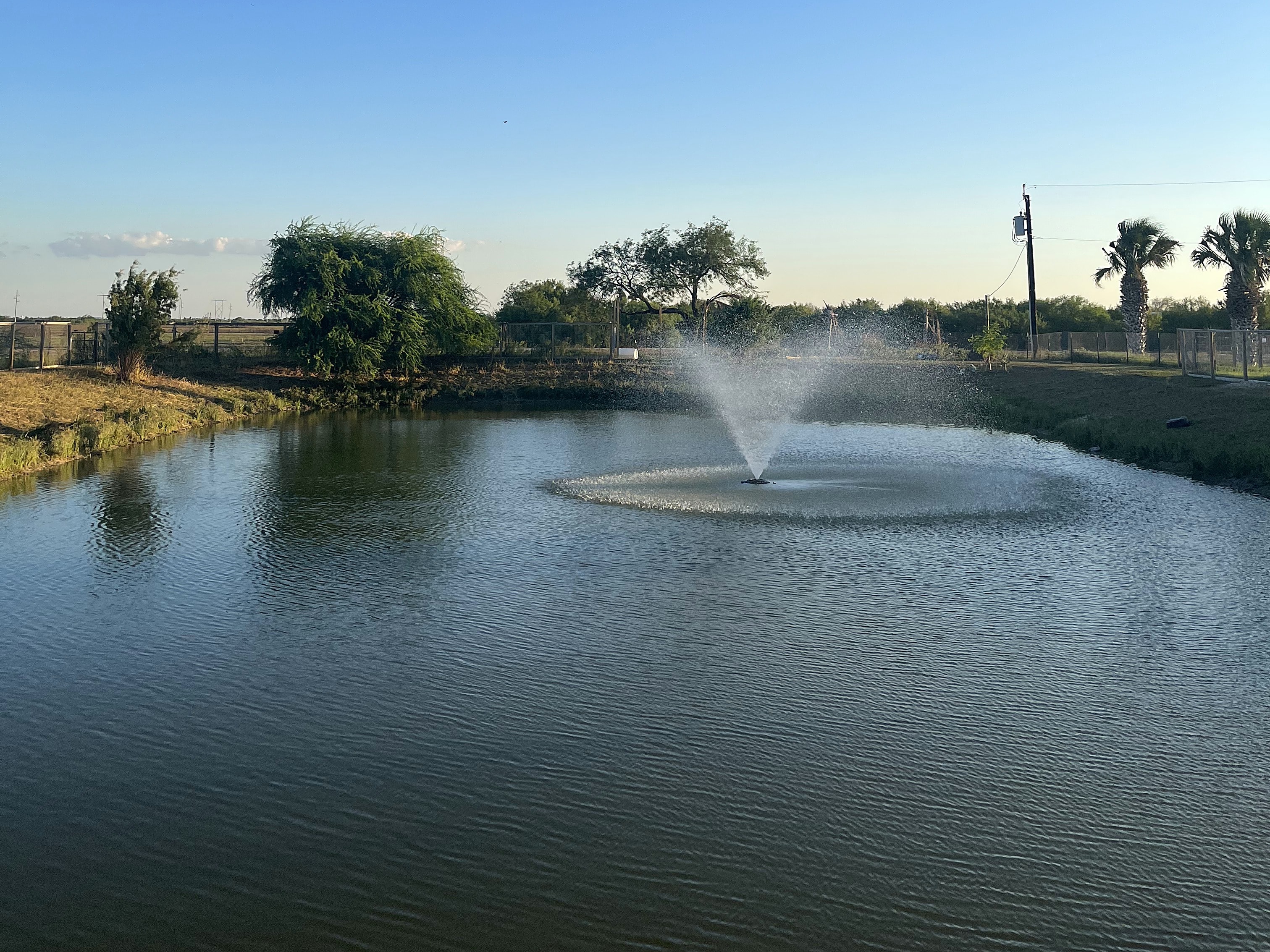 The fountain on the community pond at Rio Grande Estates in warm evening light
